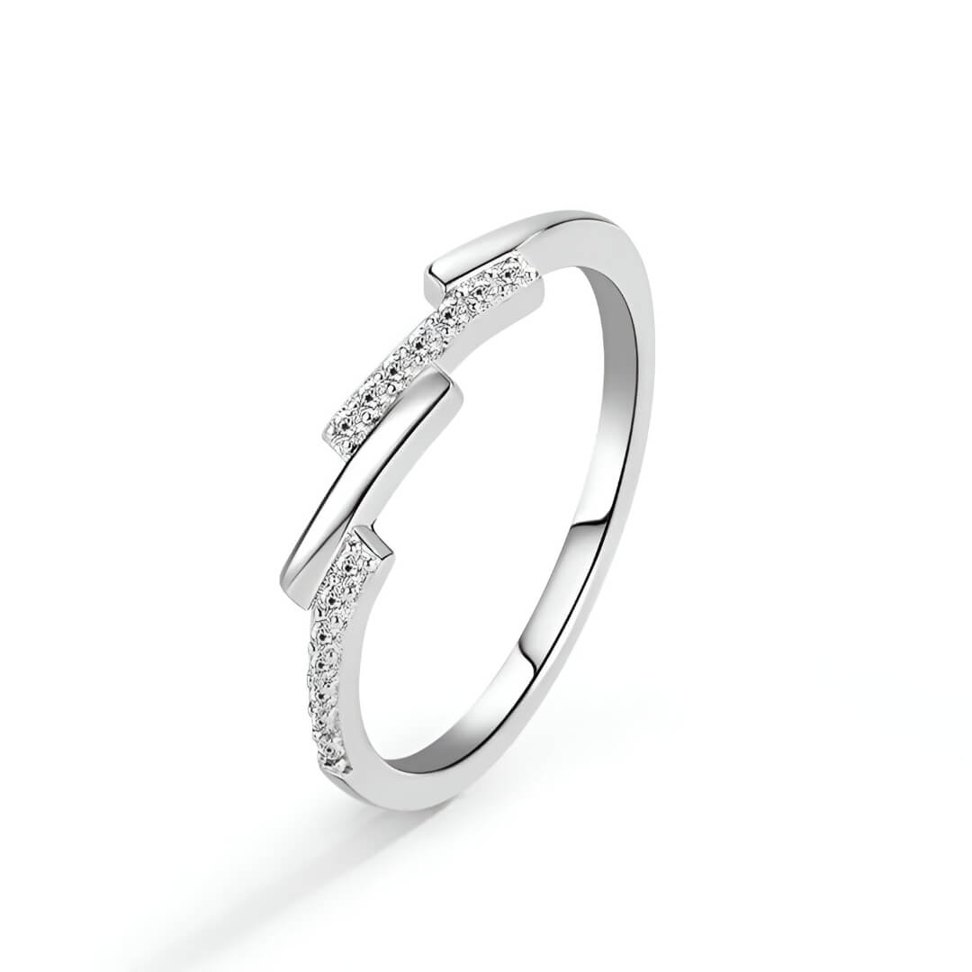 Alliance asymétrique en acier inoxydable et or blanc sertie d'oxydes de zirconium sur fond blanc.