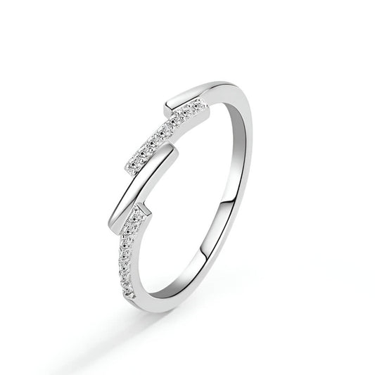 Alliance asymétrique en acier inoxydable et or blanc sertie d'oxydes de zirconium sur fond blanc.