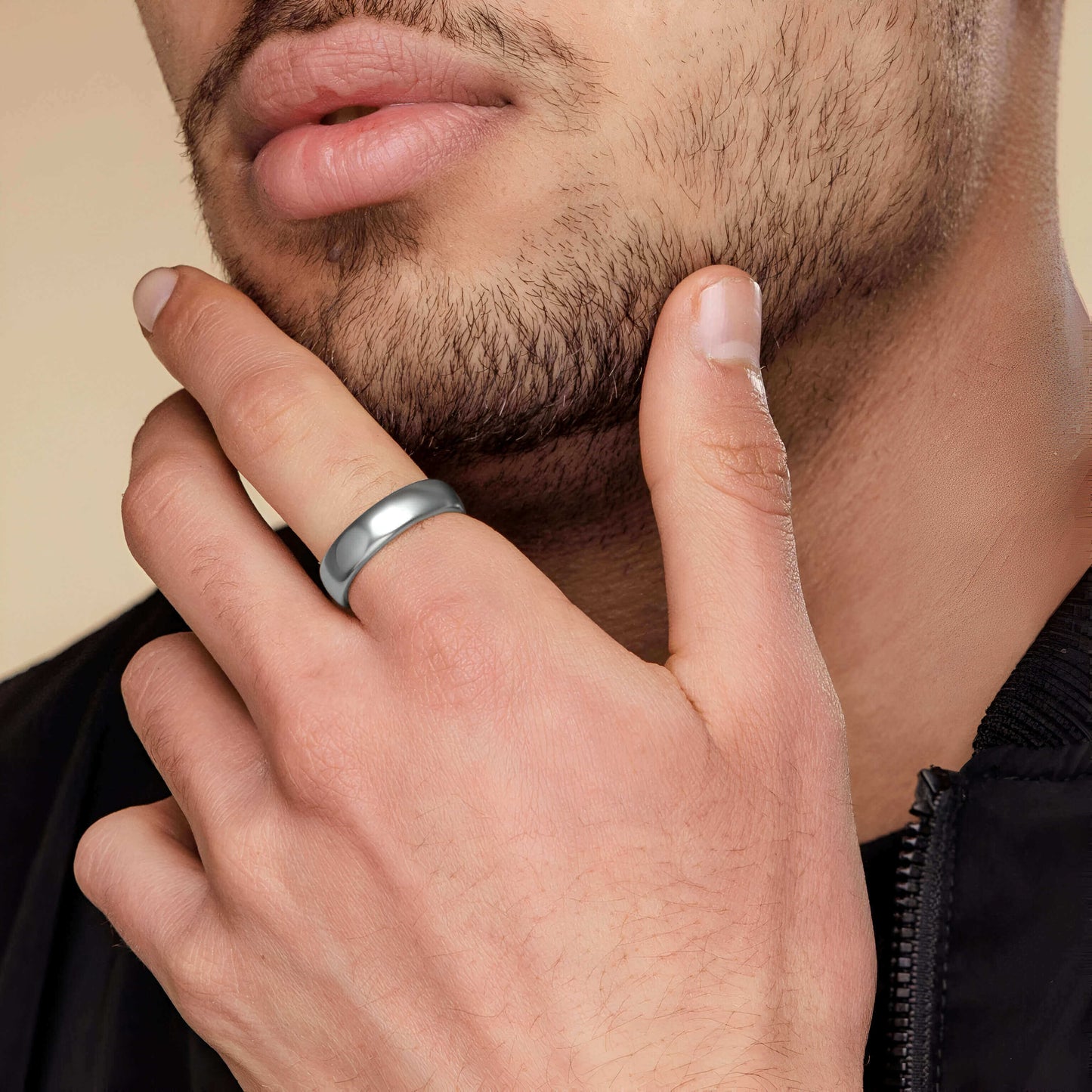 Alliance classique de mariage en acier inoxydable blanc portée au doigt d'un homme.