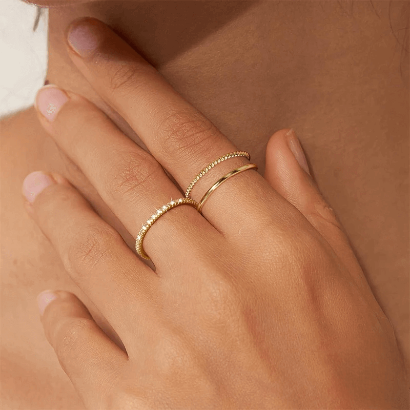Alliance d'éternité fine calyra en argent 925 plaqué or jaune et diamants portée au doigt d'une femme.