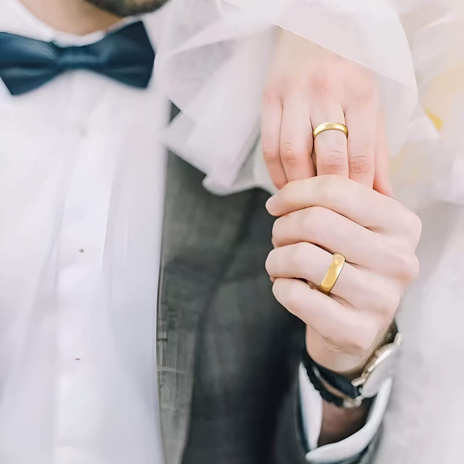 Alliance demi-jonc en or jaune portée au doigt d'un homme et d'une femme lors d'un mariage.