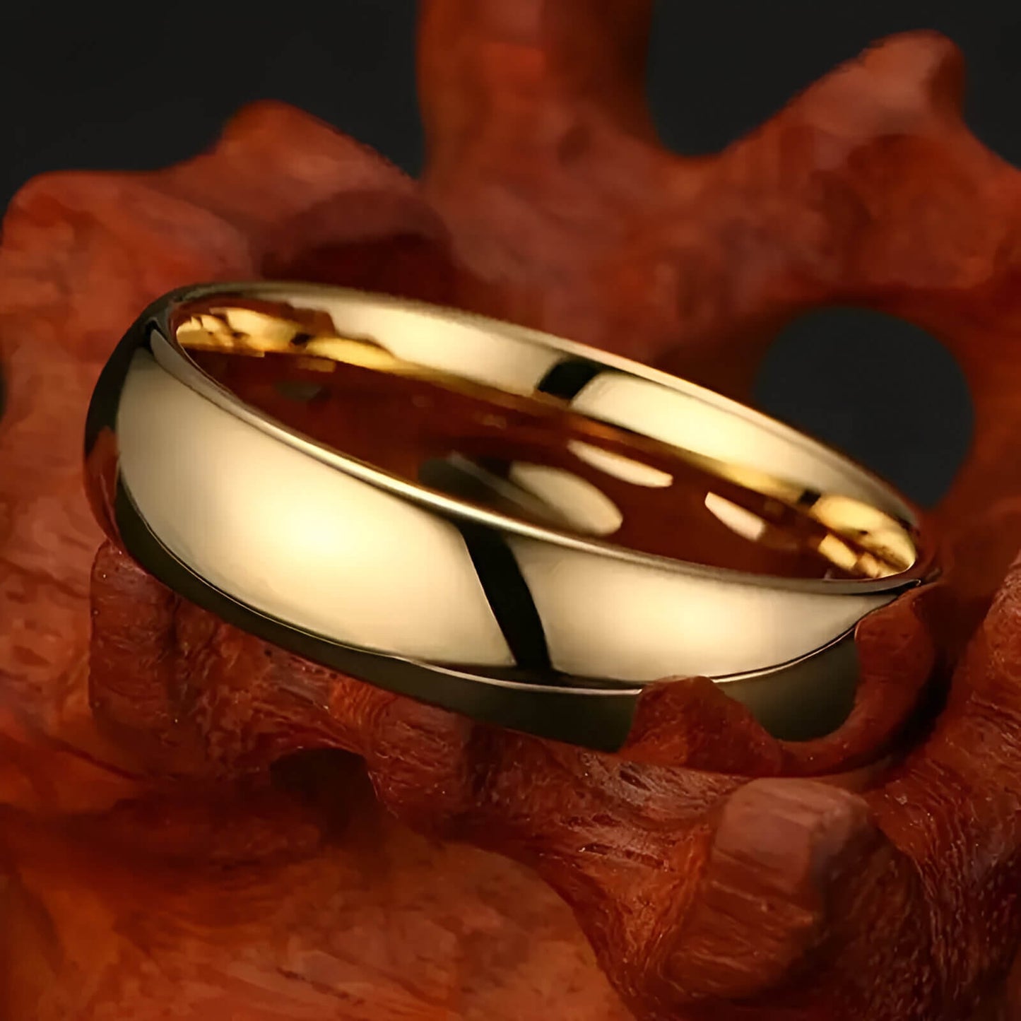 Alliance demi-jonc en or jaune à plat sur un rocher.