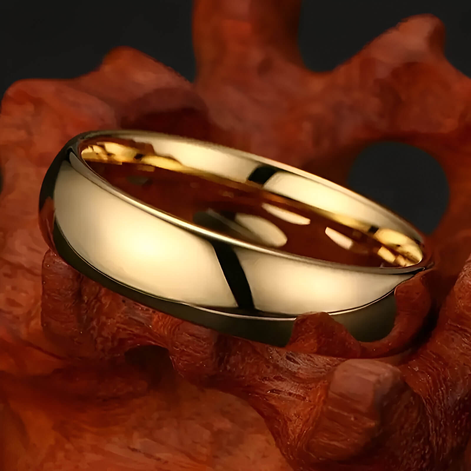 Alliance demi-jonc en or jaune à plat sur un rocher.