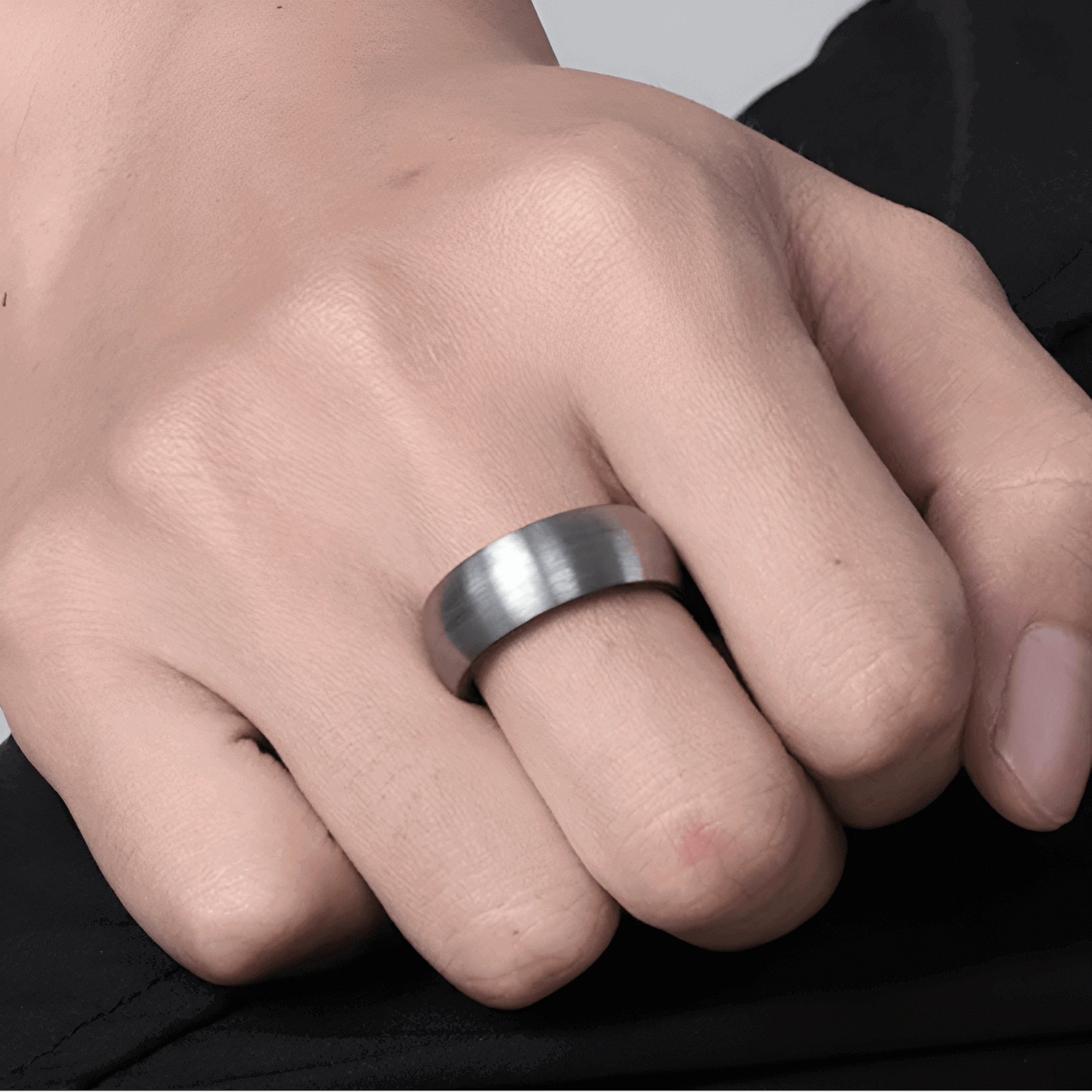 Alliance demi-jonc en tungstène blanc de 8 mm portée au doigt d'un homme.