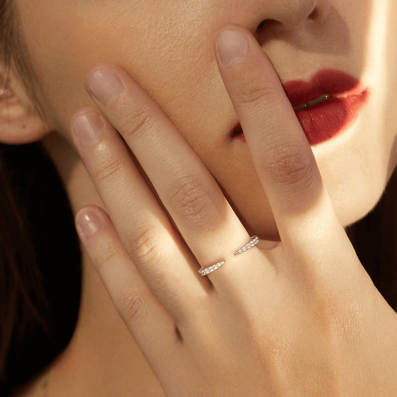 Alliance élancé en argent 925 plaqué platine et zircons portée au doigt d'une femme vue de face.
