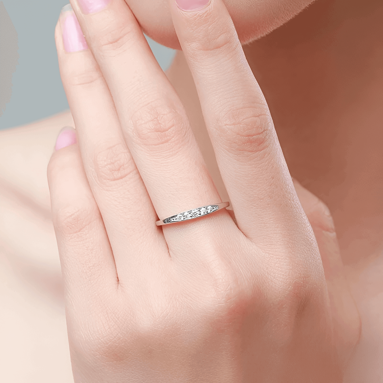 Alliance en or blanc et diamants naturels portée au doigt d'une femme.