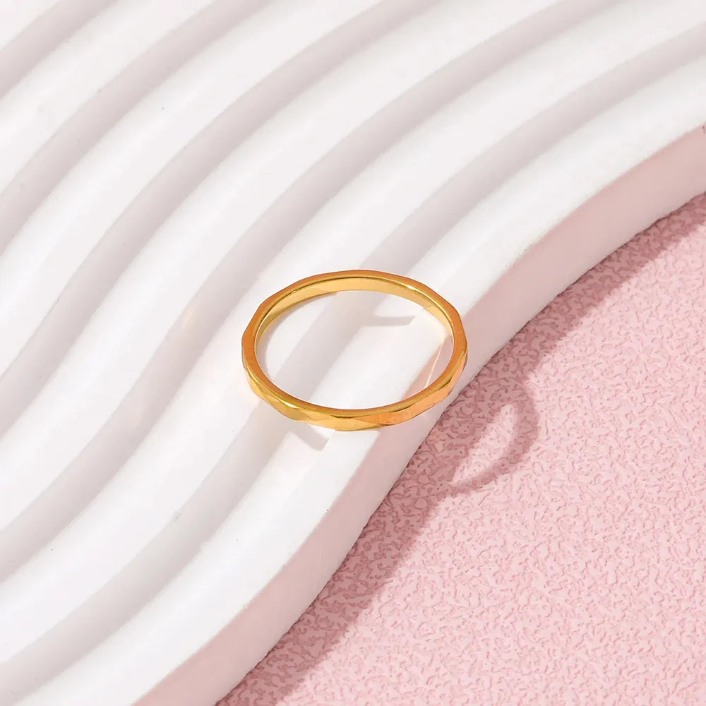 Alliance en or tendance posée sur fond blanc - bague fine plaquée or 14K élégante et moderne
