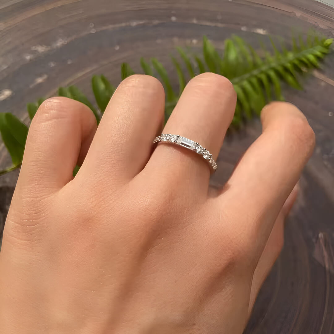 Alliance en or blanc et oxyde de zirconium portée au doigt d'une femme.