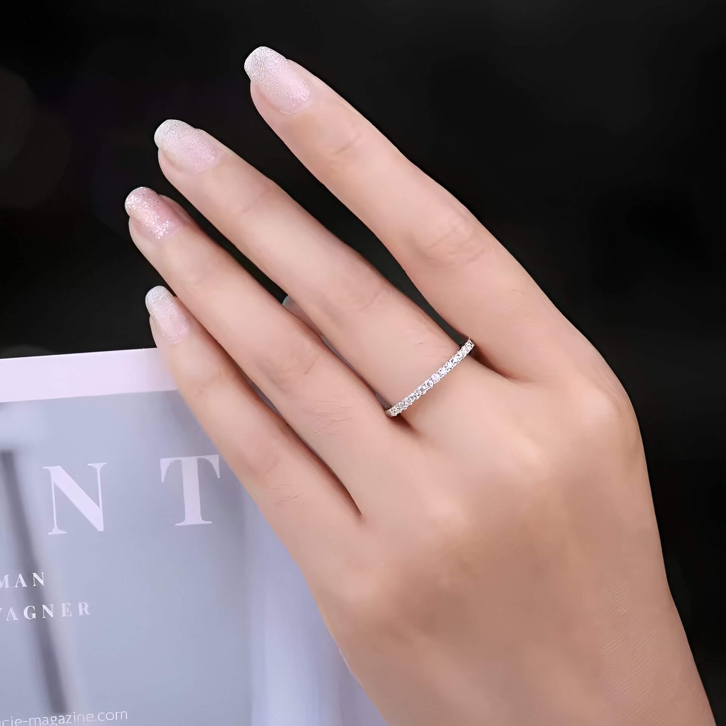 Alliance éternité en or blanc et diamants naturels portée au doigt d'une femme.