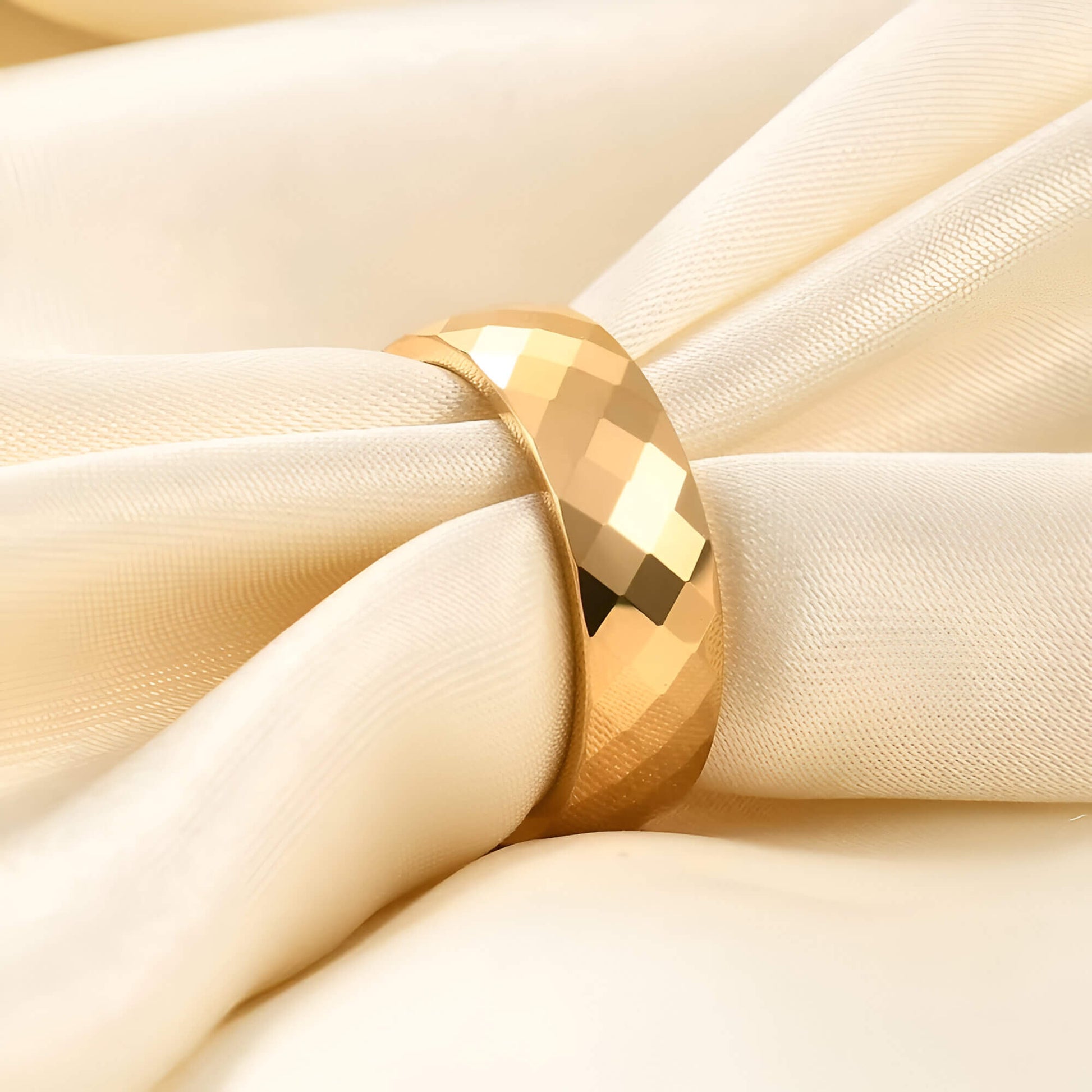 Alliance facettée de 6mm en tungstène et or jaune portée par une nappe.