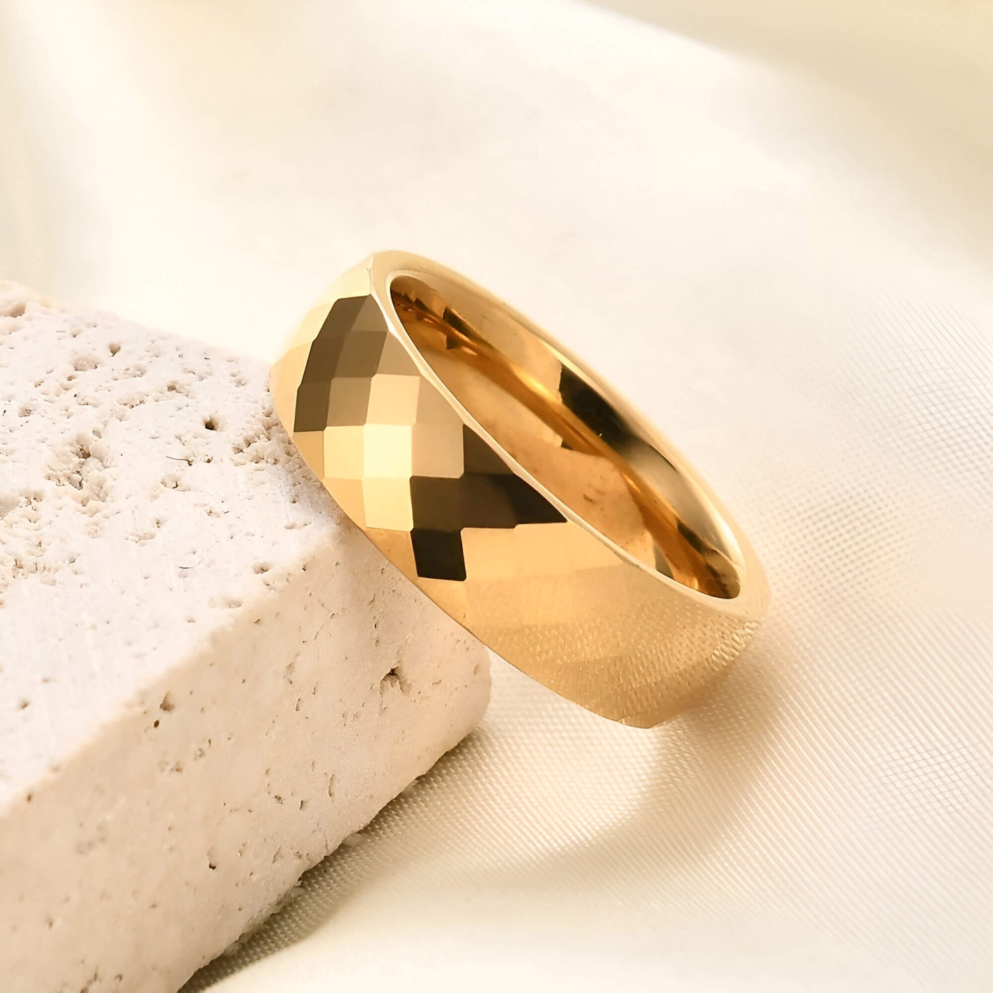 Alliance facettée de 6mm en tungstène et or jaune posée.