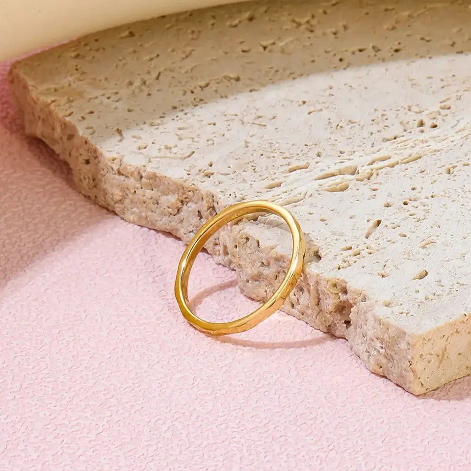 Alliance fine facettée en acier doré posée.