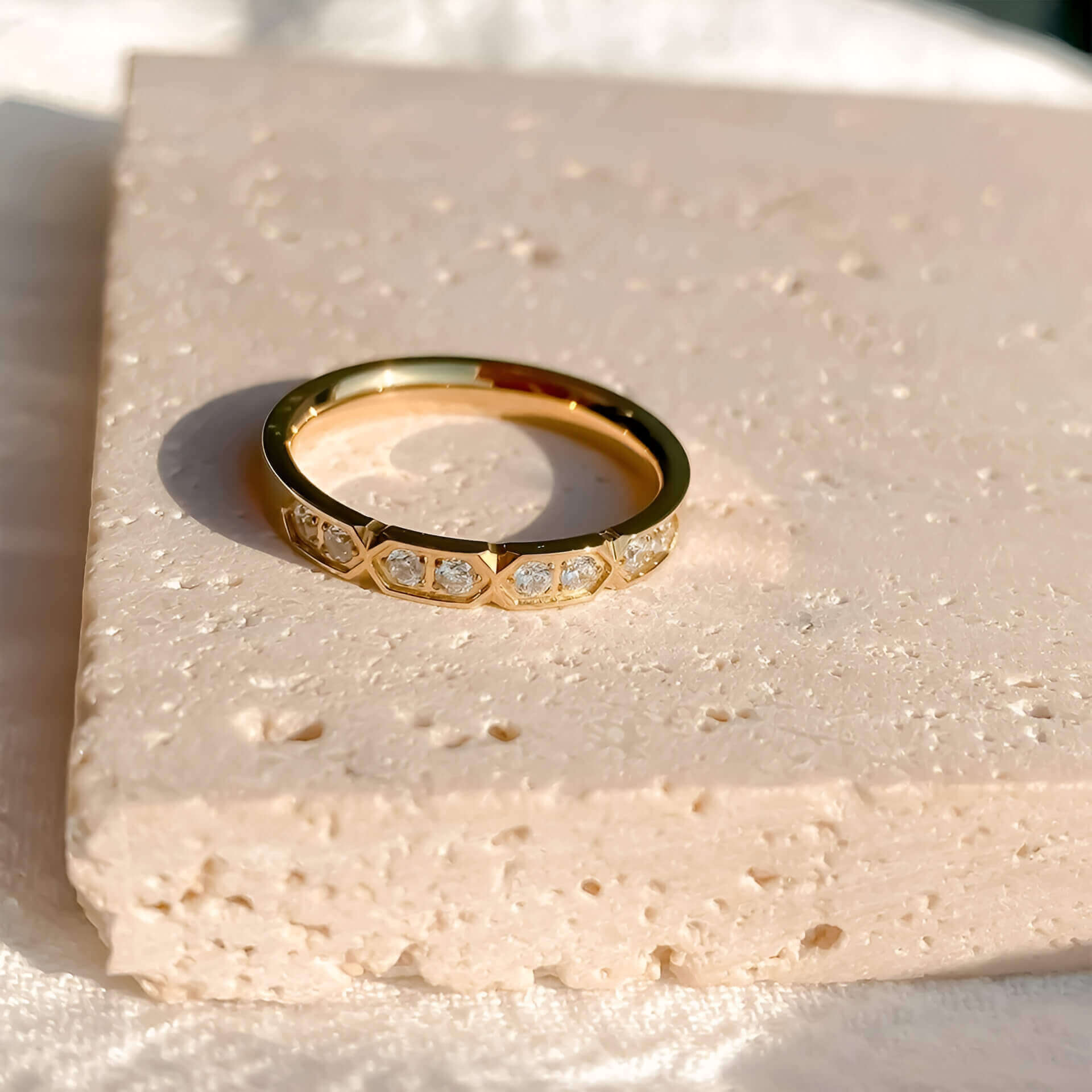 Alliance gravée alvéolée en acier inoxydable et or jaune sertie de cristaux à plat.