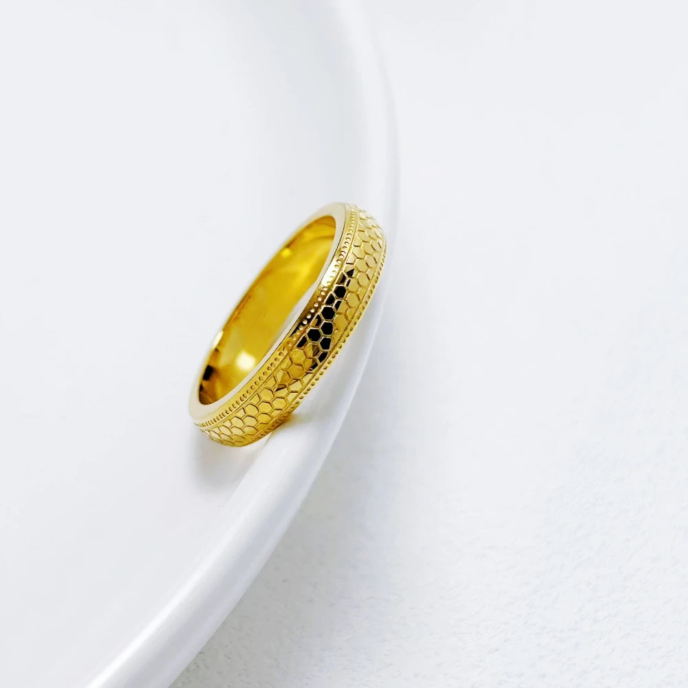 Alliance gravée en acier inoxydable et or jaune posée.