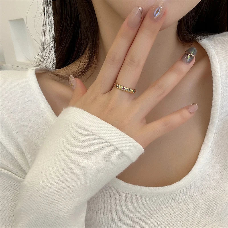 Alliance jonc soleil en acier doré sertie de diamants naturels portée au doigt d'une femme.