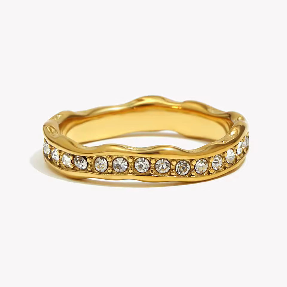 Alliance ondulée en acier et or jaune sertie de diamants naturels sur fond blanc.