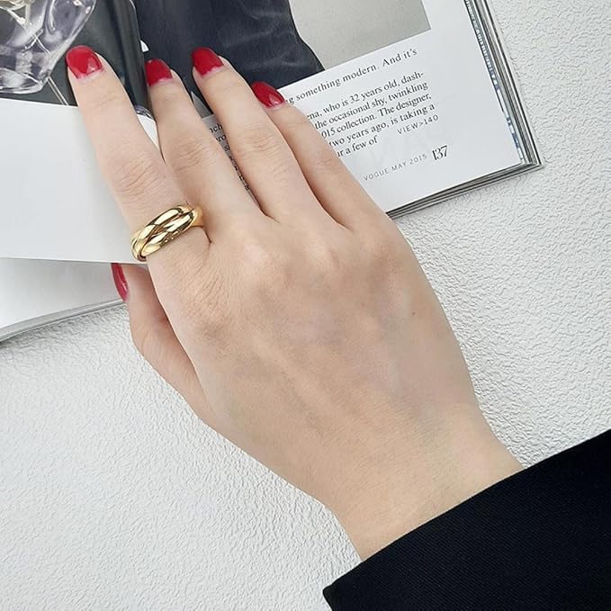 Main de femme portant au doigt une alliance triple anneau variante en or jaune.