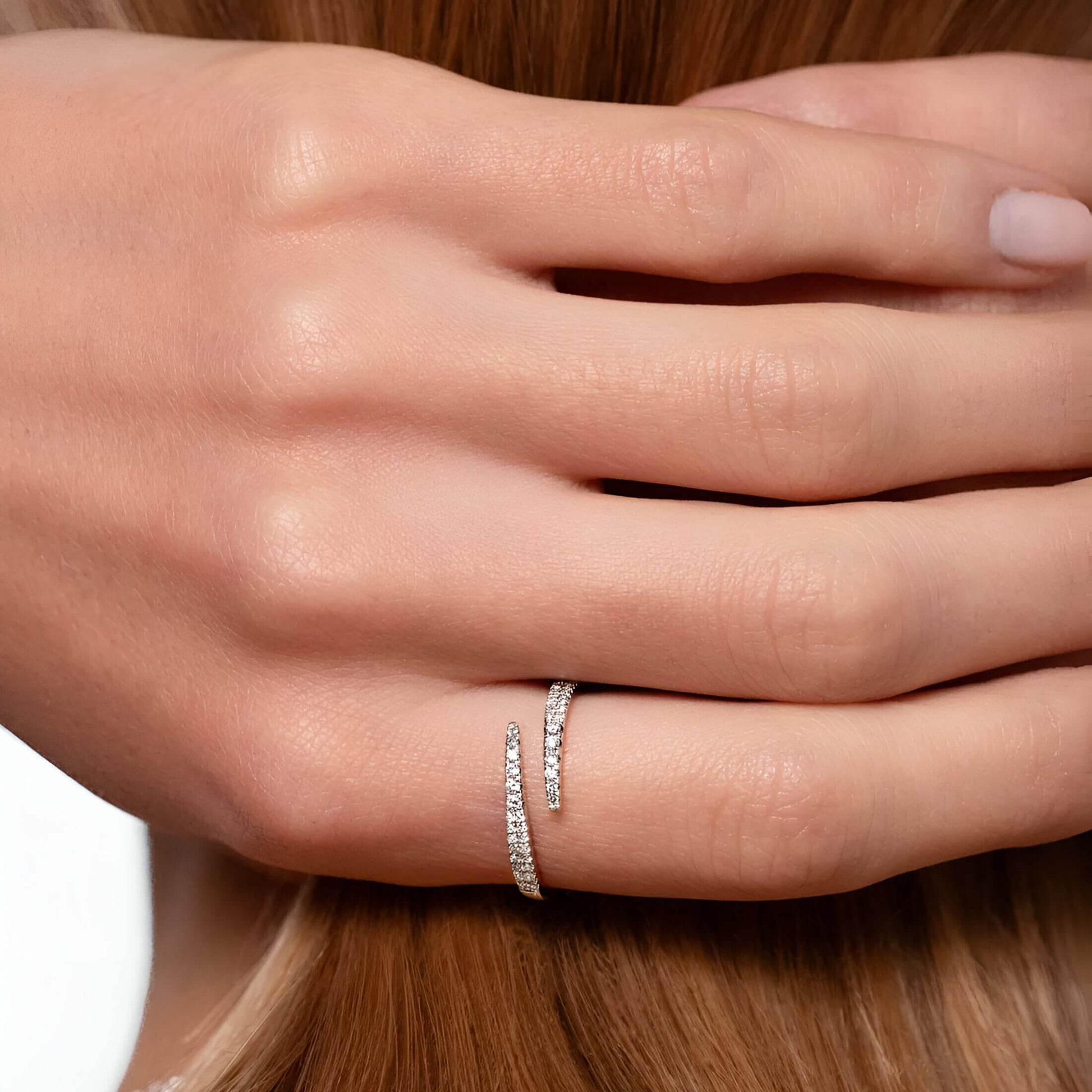 Alliance ouverte croisée en or blanc et diamants naturels portée au doigt d'une femme vue de face.
