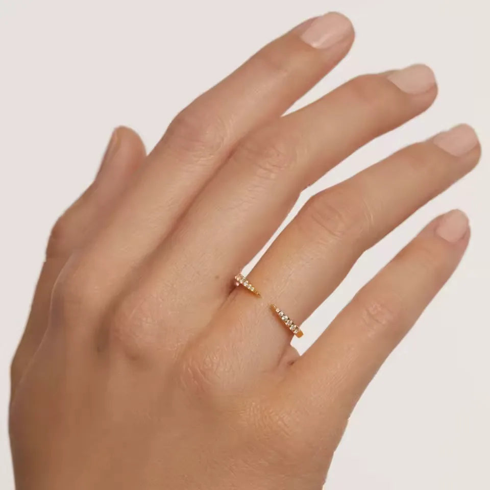 Alliance ouverte pointu en or jaune et diamants naturels portée au doigt d'une femme.