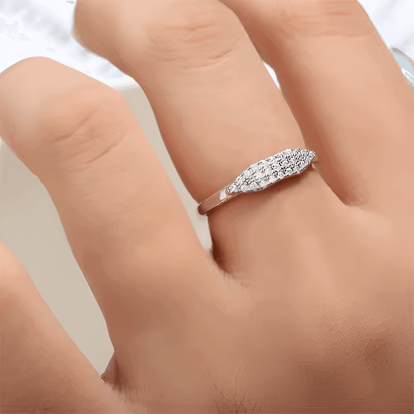 Alliance pavé en or blanc et oxydes de zirconium portée au doigt d'une femme.
