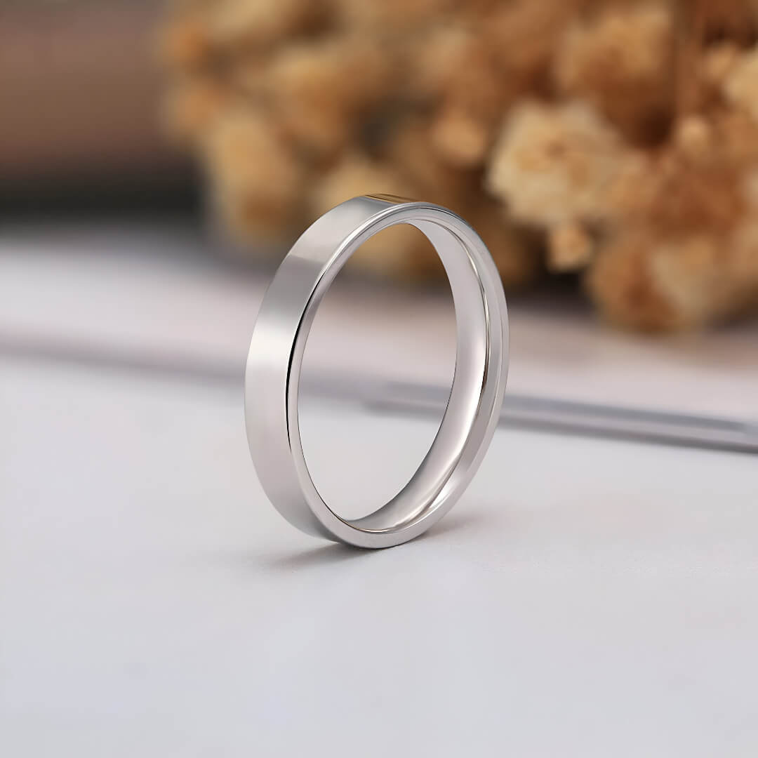 Alliance ruban épurée en argent et or blanc debout.