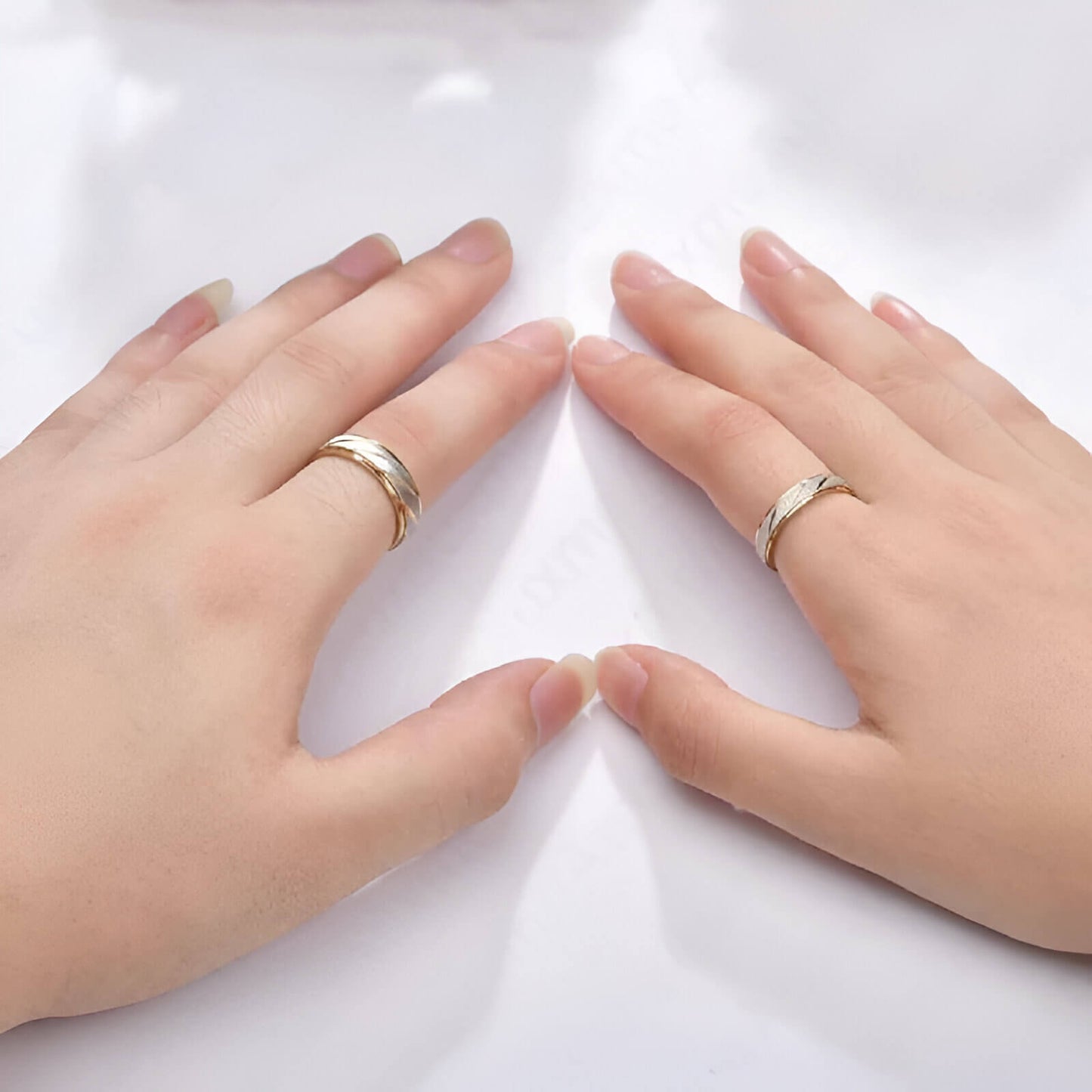 Alliances ruban en acier inoxydable plaqué or jaune de 4mm et 6mm portées aux doigts d'une femme.