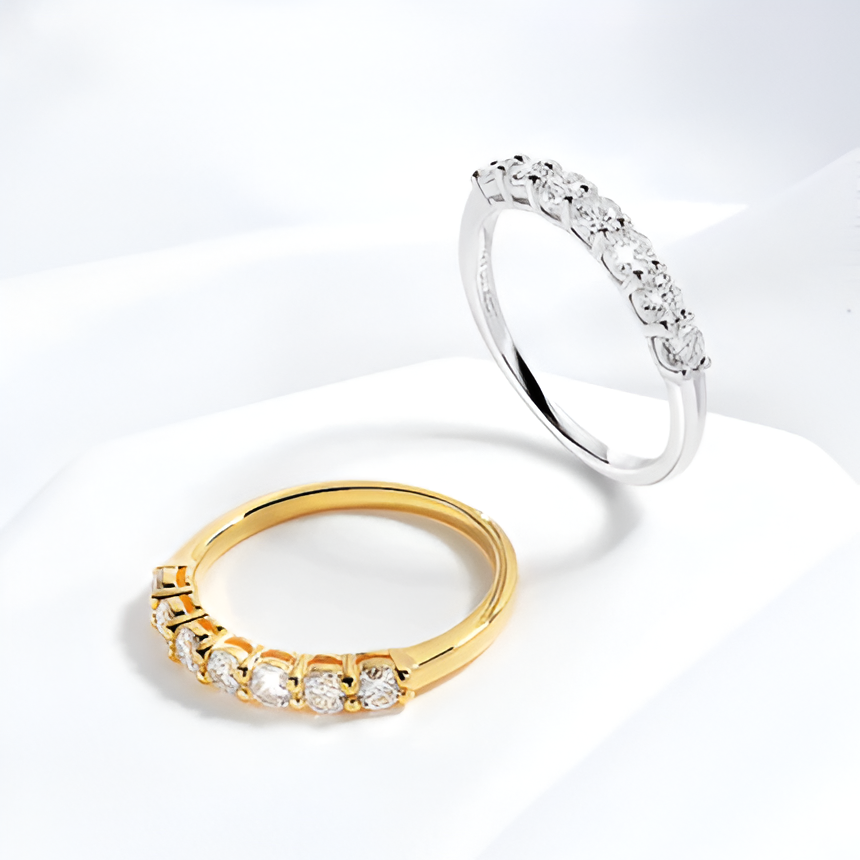 Alliances semi-éternité en or jaune et or blanc serties de diamants synthétiques sur socle blanc.
