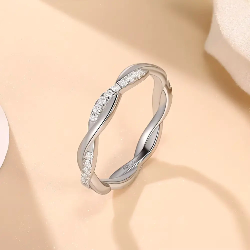 Alliance torsadée en or blanc et diamants synthétiques debout.