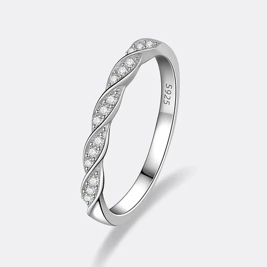 Alliance torsadée en or blanc et diamants synthétiques sur fond gris clair.