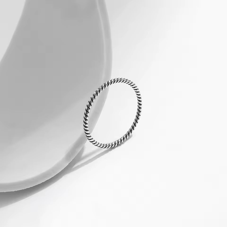 Alliance torsadée en argent 925 et rhodium debout.