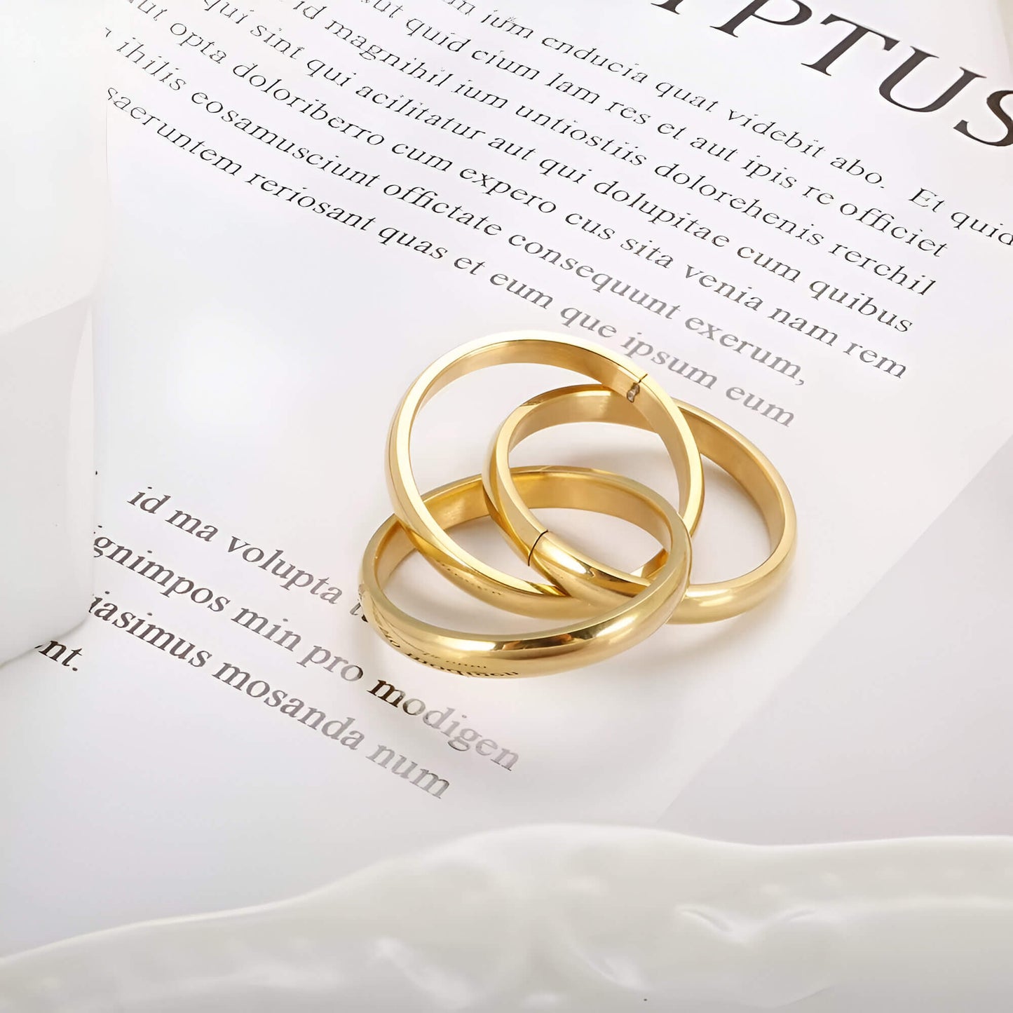 Alliance triple demi-jonc en acier plaqué or jaune posée.