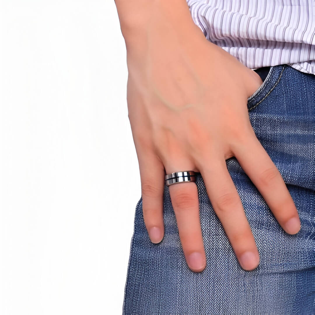 Bague à bande en acier blanc portée au doigt d'un homme.