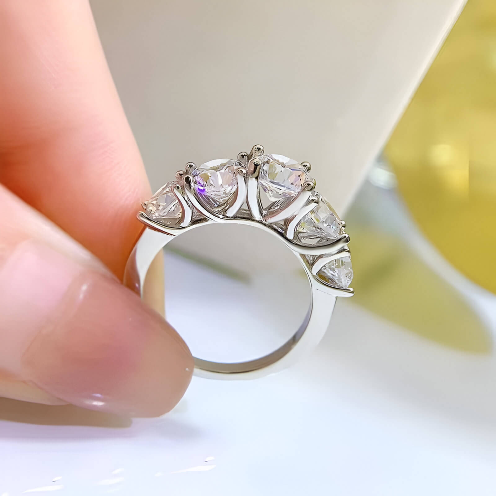 Bague de fiançailles cinq pierres en or blanc et diamants synthétiques vue latérale.