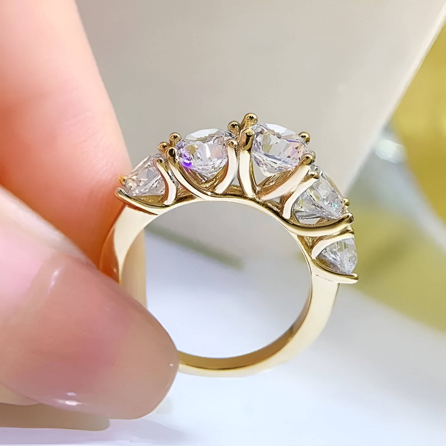 Bague de fiançailles cinq pierres en or jaune et diamants synthétiques vue latérale.