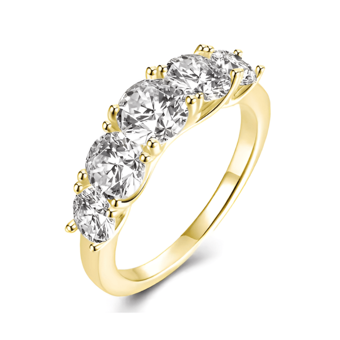 Bague de fiançailles cinq pierres en or jaune et diamants synthétiques sur fond blanc.