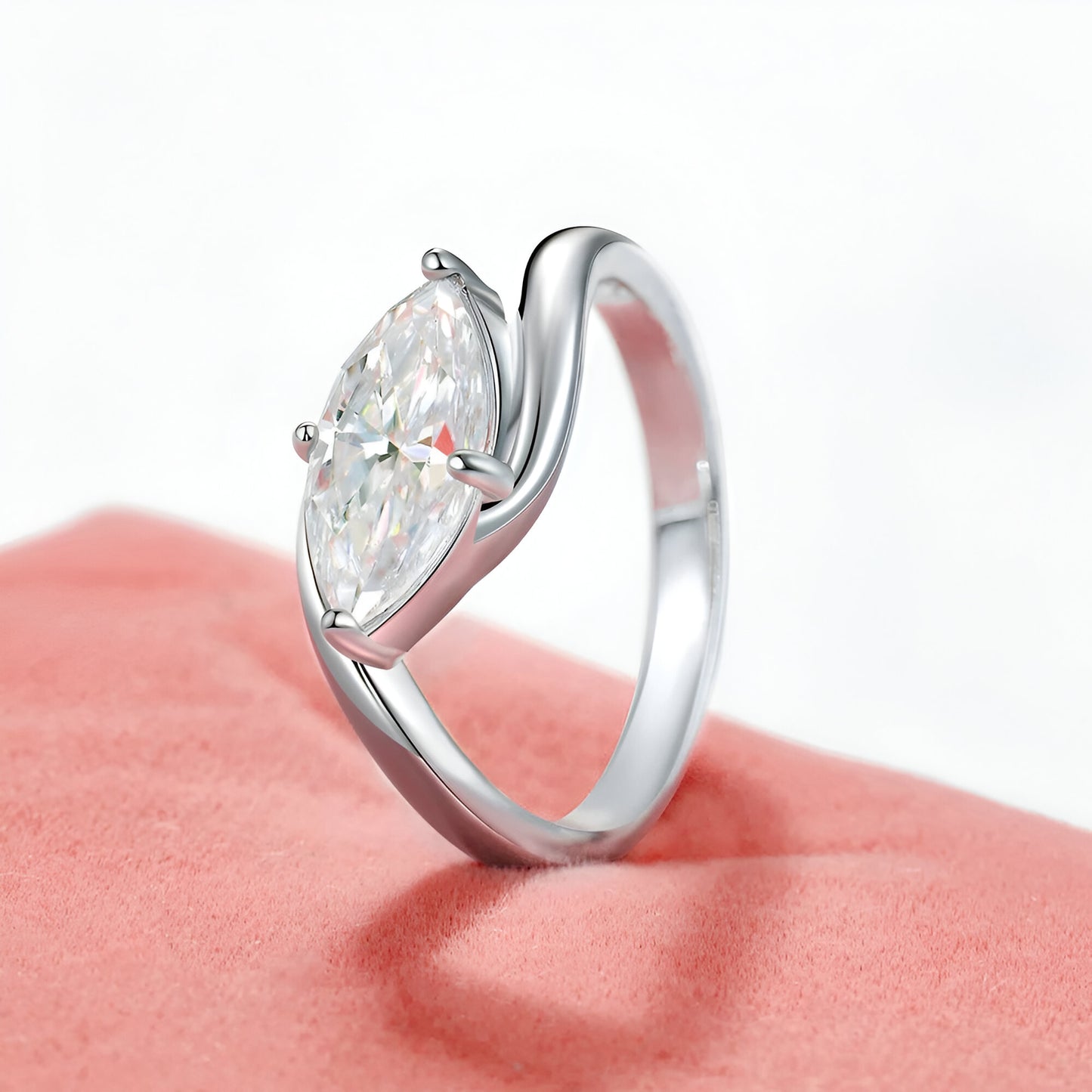 Bague de fiançailles en argent 925 sur écrin rose, vue semi-latérale, mettant en valeur son diamant moissanite taillé en coussin et son plaquage or blanc 18K.