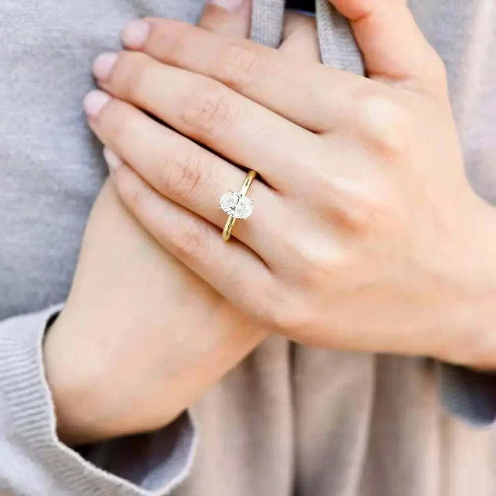 Femme portant une bague de fiançailles en or 14K Serres d'Aigle, rayon de lumière sur doigt, bijou élégant