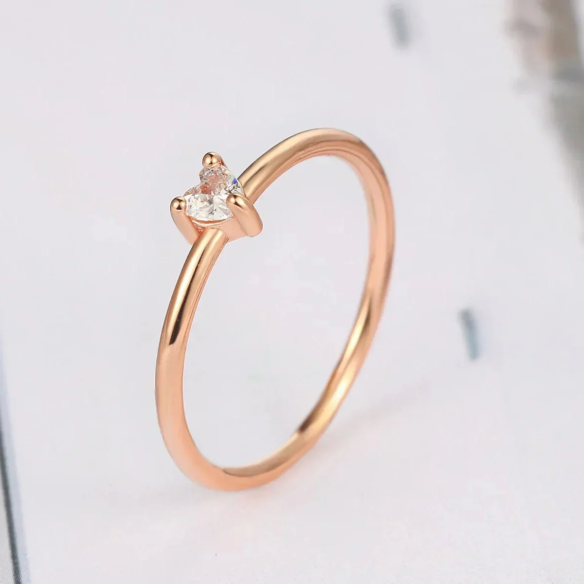 Vue latérale de la bague de fiançailles en or rosé cœur élégant, diamant de zircon cubique, plaquage or rosé 14K, un design épuré et moderne - La Petite Rebelle