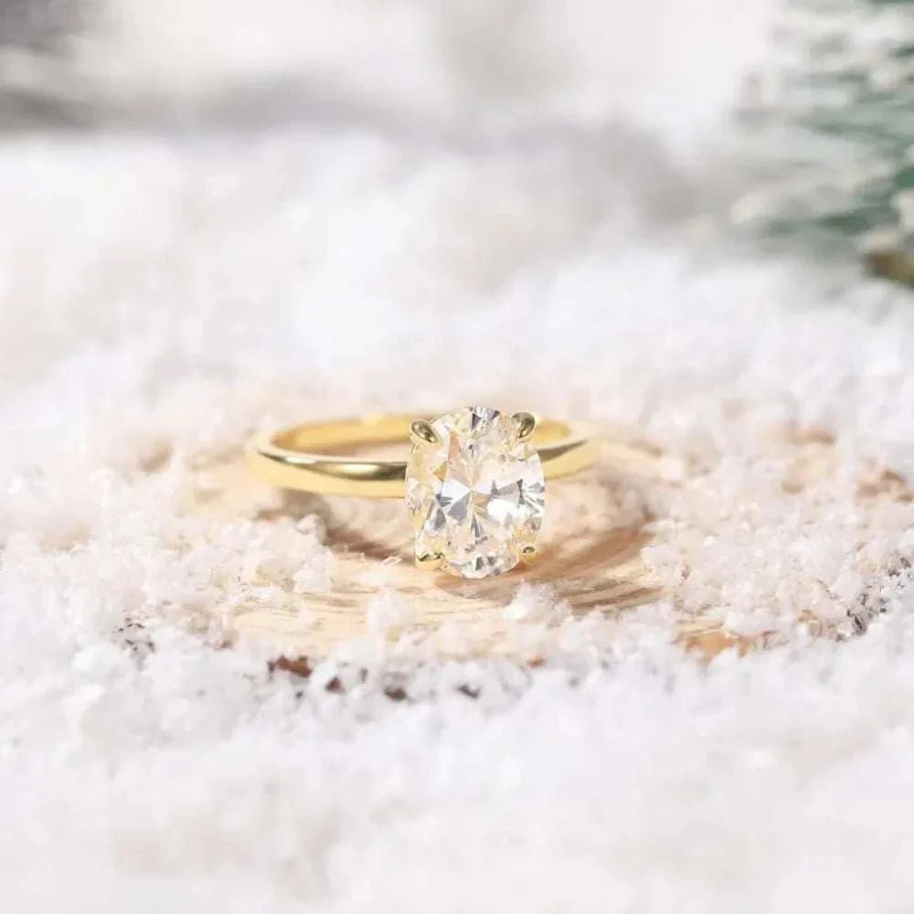 Bague de fiançailles en or 14K vue de loin sur surface cotonneuse, design raffiné avec zircon cubique et plaquage or