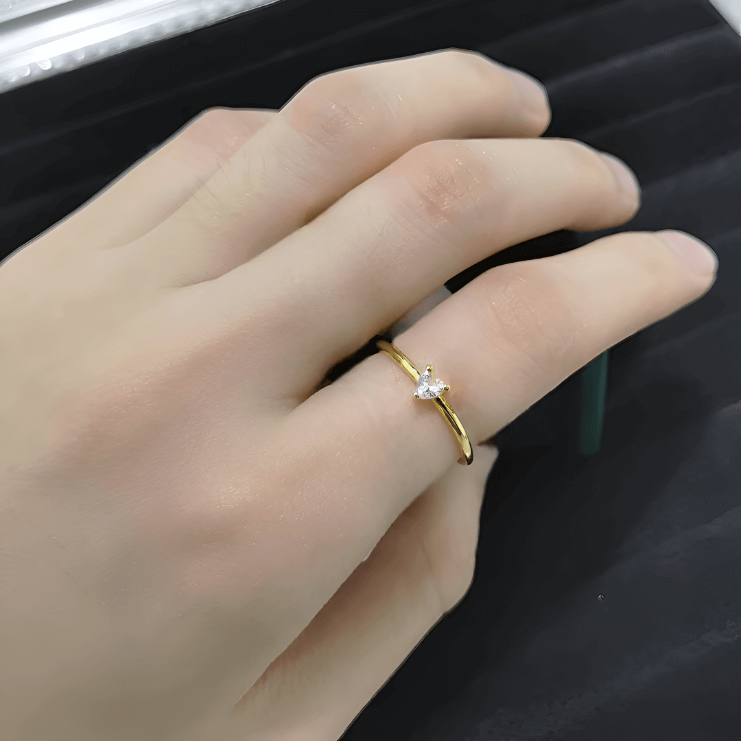 Bague fantaisie en or jaune et oxyde de zirconium portée sur l'index d'une femme.