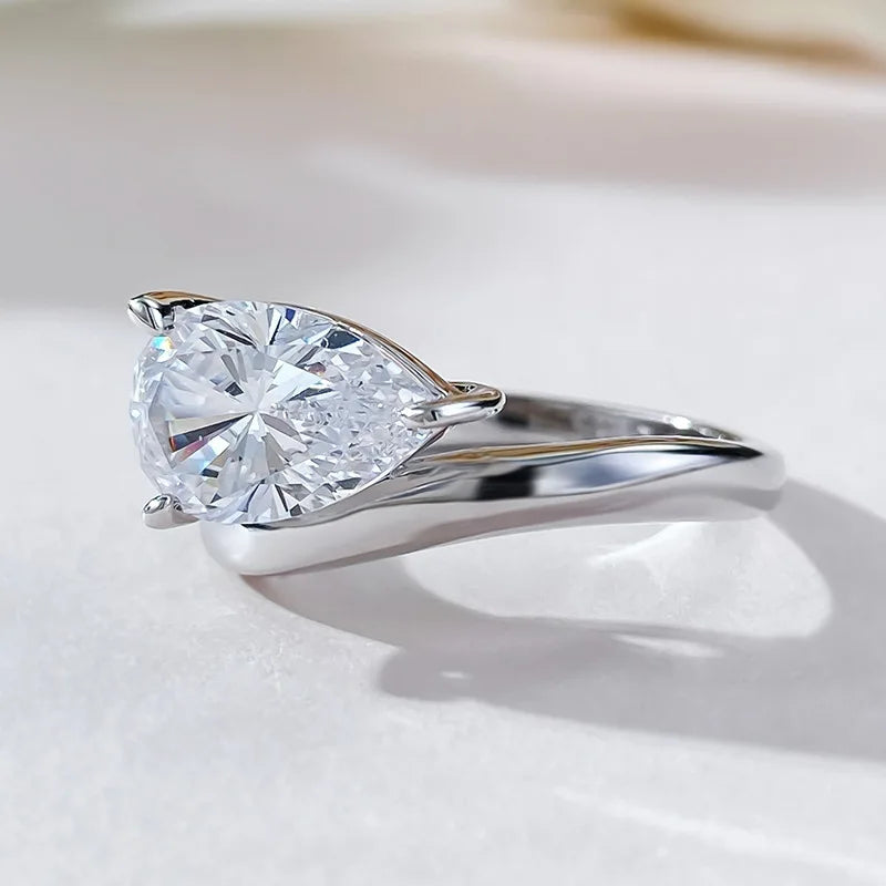 Bague solitaire goutte de lumière en argent à plat vue de côté.