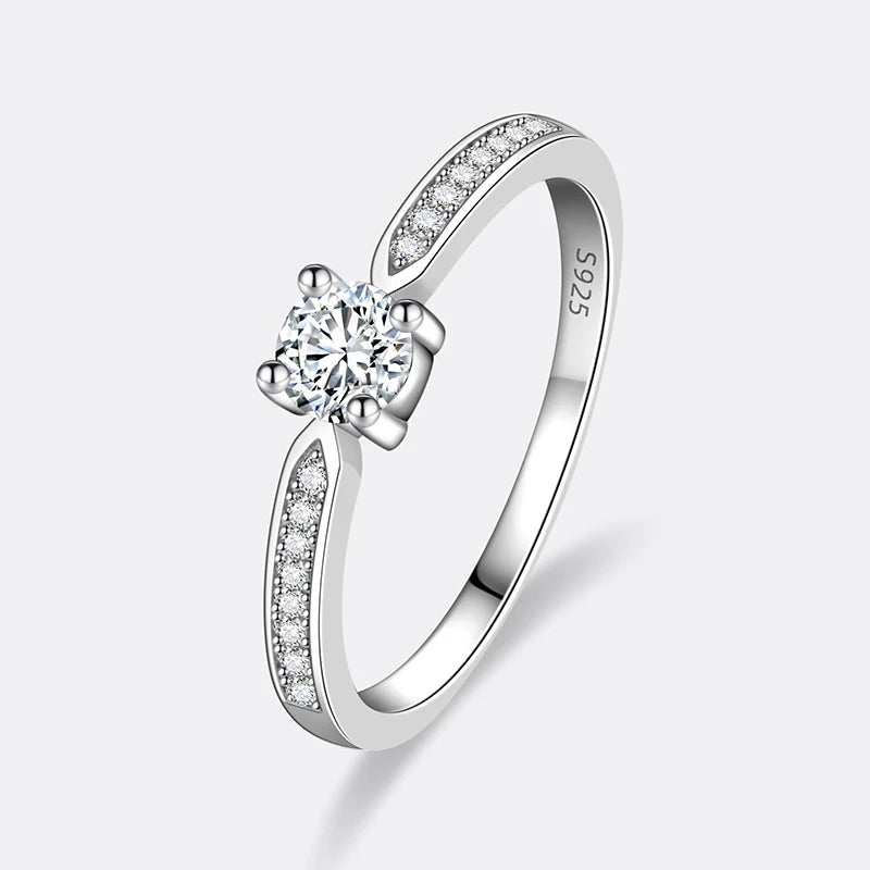 Bague solitaire emprise de moissanite debout sur fond blanc cassé.