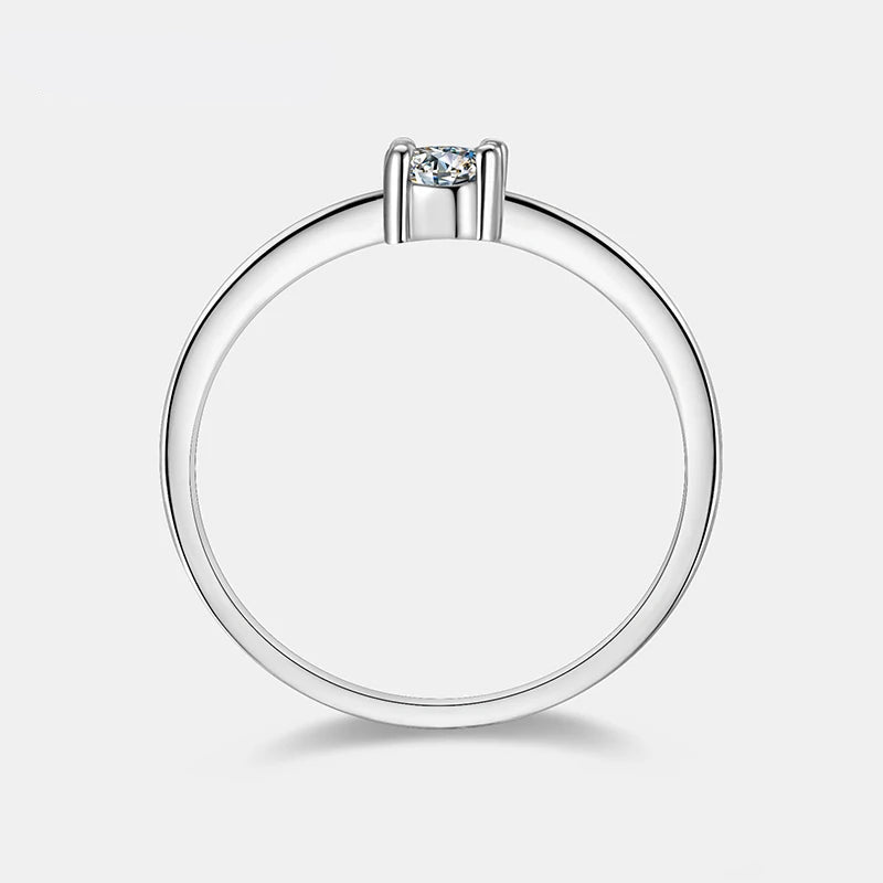 Bague solitaire emprise de moissanite vue latérale sur fond blanc cassé.