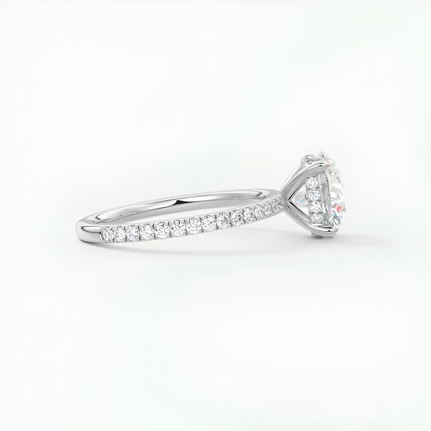 Bague solitaire rhodiée diamant rond en argent à plat vue de côté sur fond blanc.