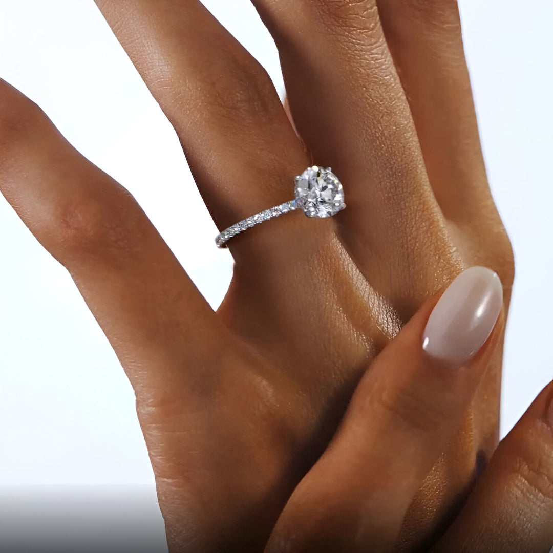 Bague solitaire rhodiée diamant rond en argent portée au doigt d'une femme.