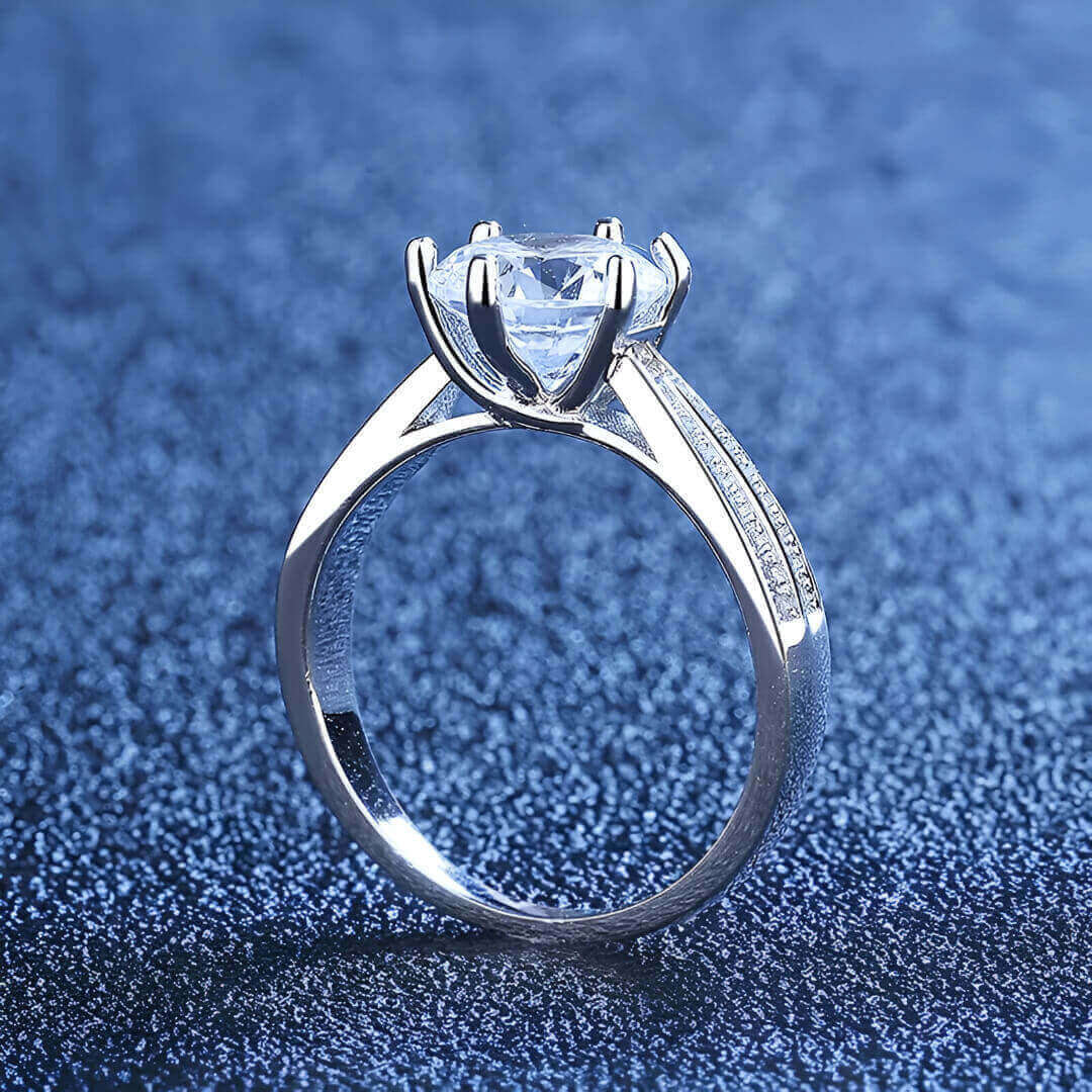 Bague solitaire double anneau serti de diamants vue latérale sur du granite bleu.