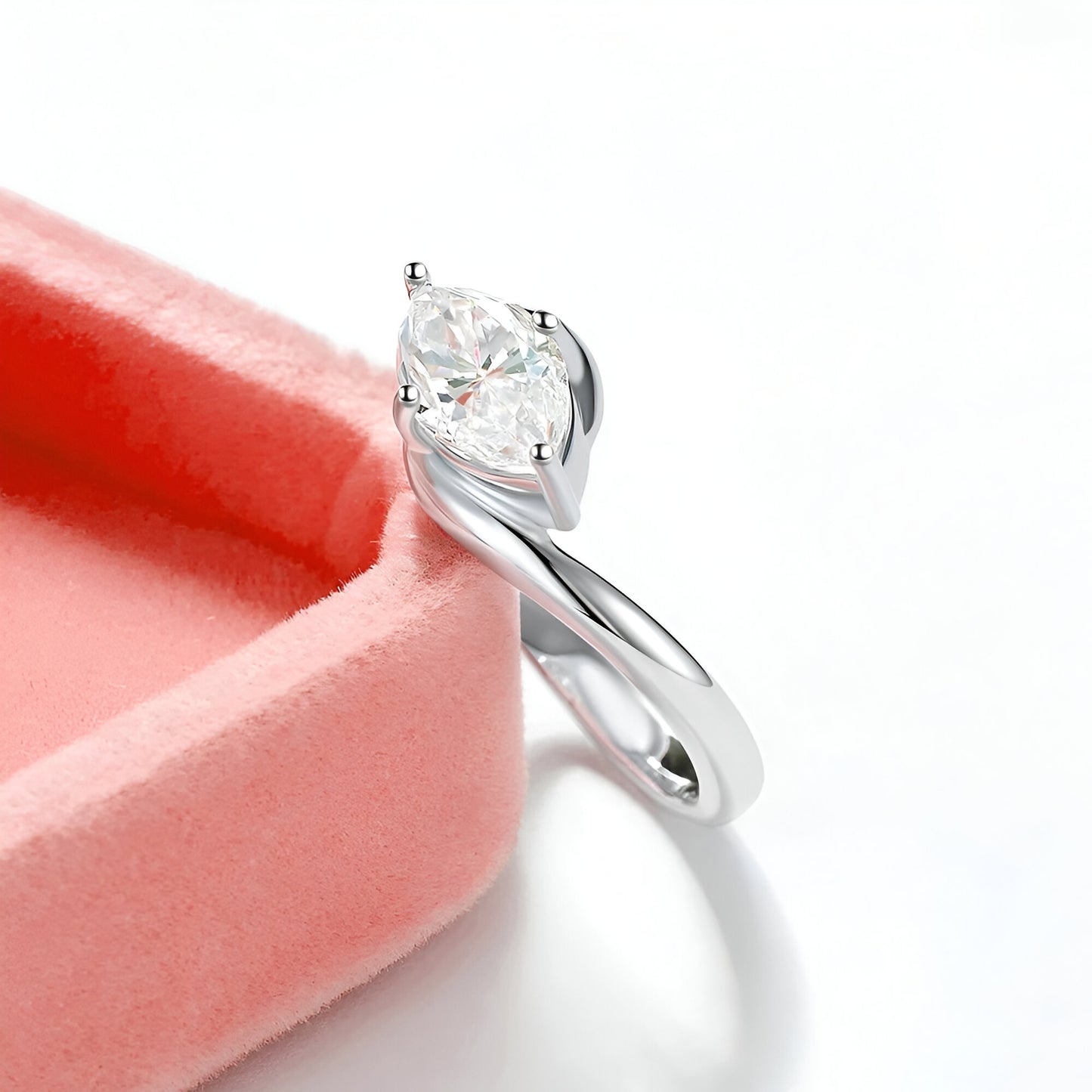 Bague diamant marquis solitaire posée sur un rebord rose bonbon.