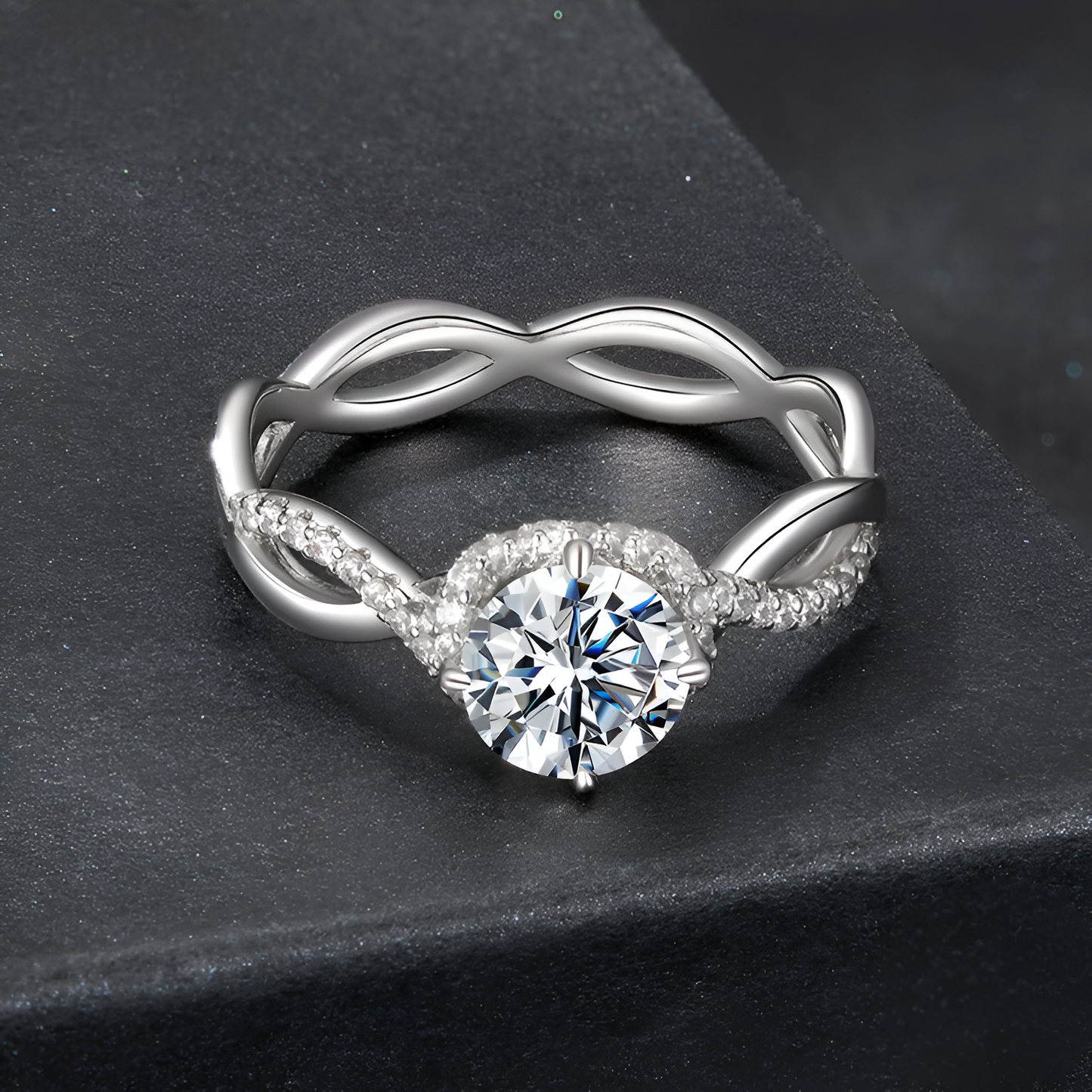 Bague solitaire ondulation de moissanite à plat vue de face sur un socle noir.