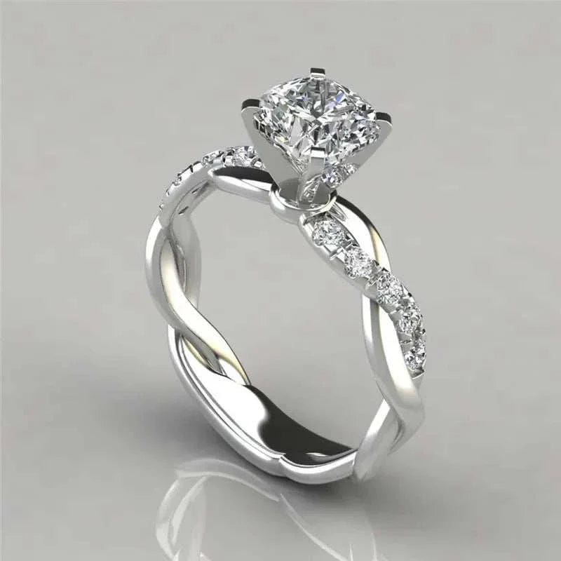 Bague solitaire tresse sertie de diamants debout vue de côté sur fond gris clair.