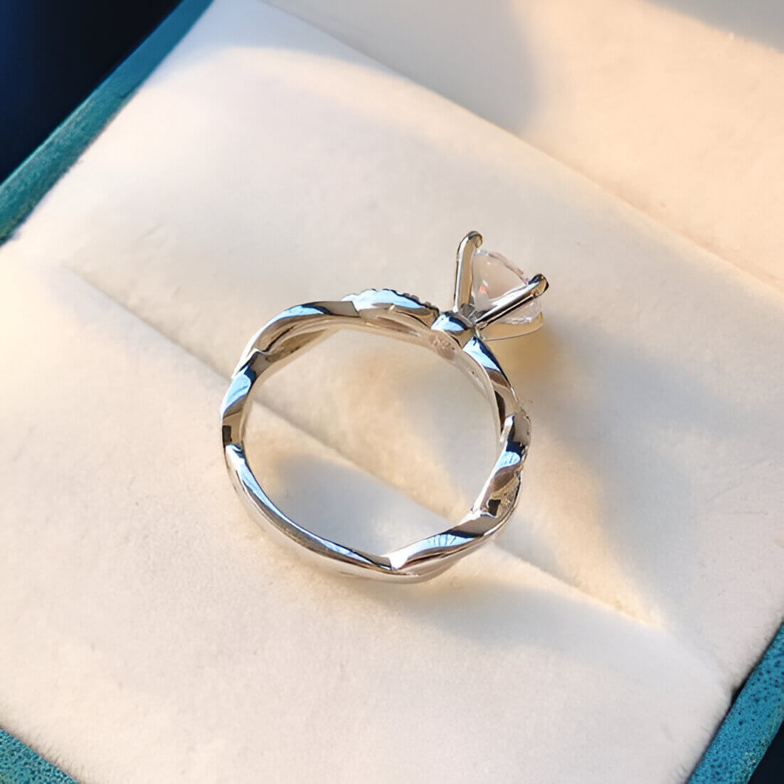 Bague solitaire tresse sertie de diamants à plat vue de dessus dans son écrin.
